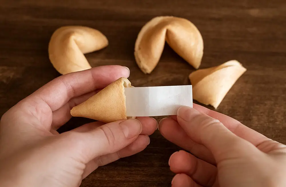 フォーチュンクッキーを割って中に入っている紙片を取り出しているところ